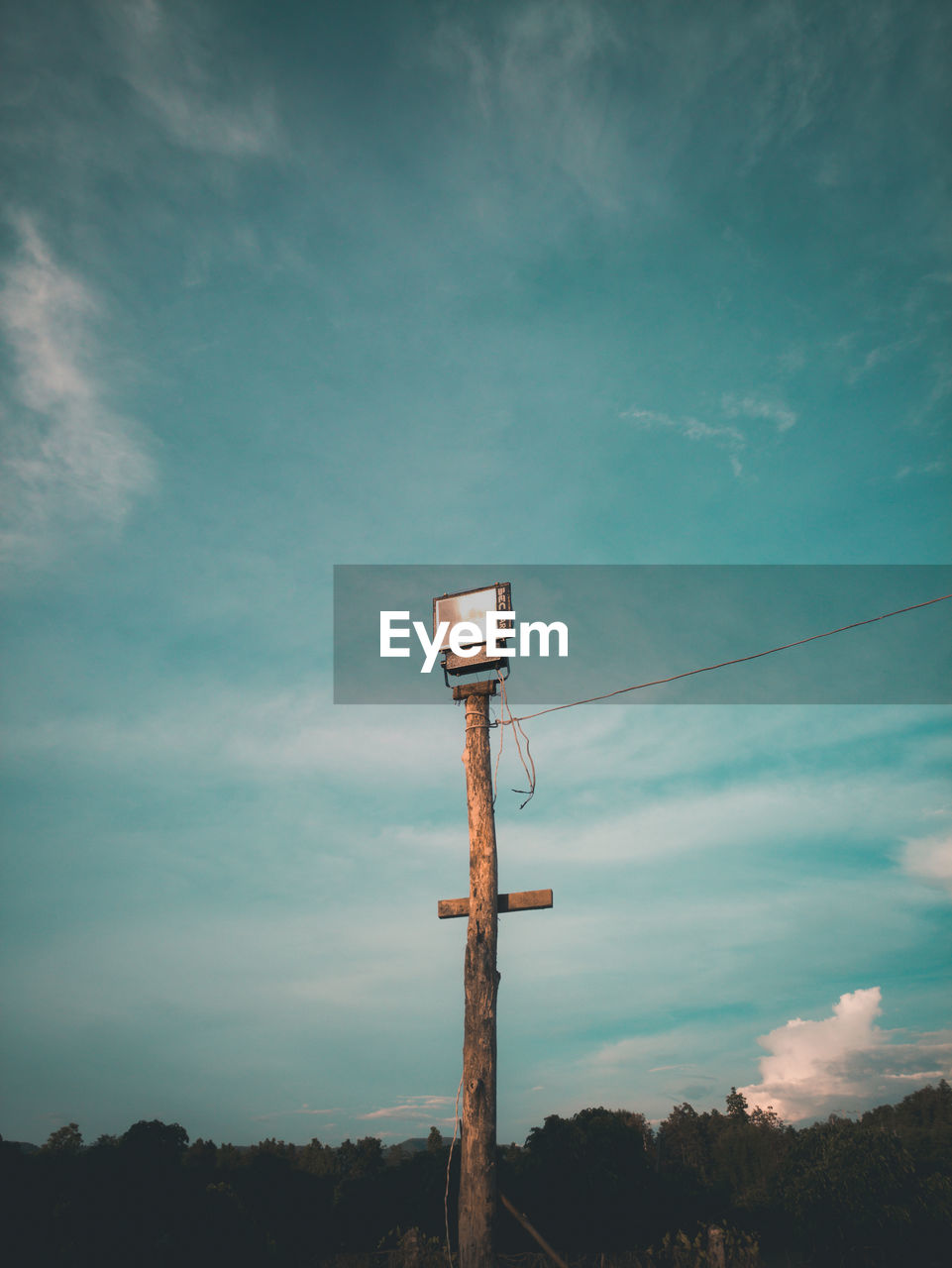 LOW ANGLE VIEW OF TELEPHONE POLE AGAINST BLUE SKY