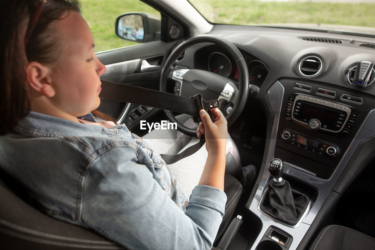 MIDSECTION OF MAN SITTING AT CAR