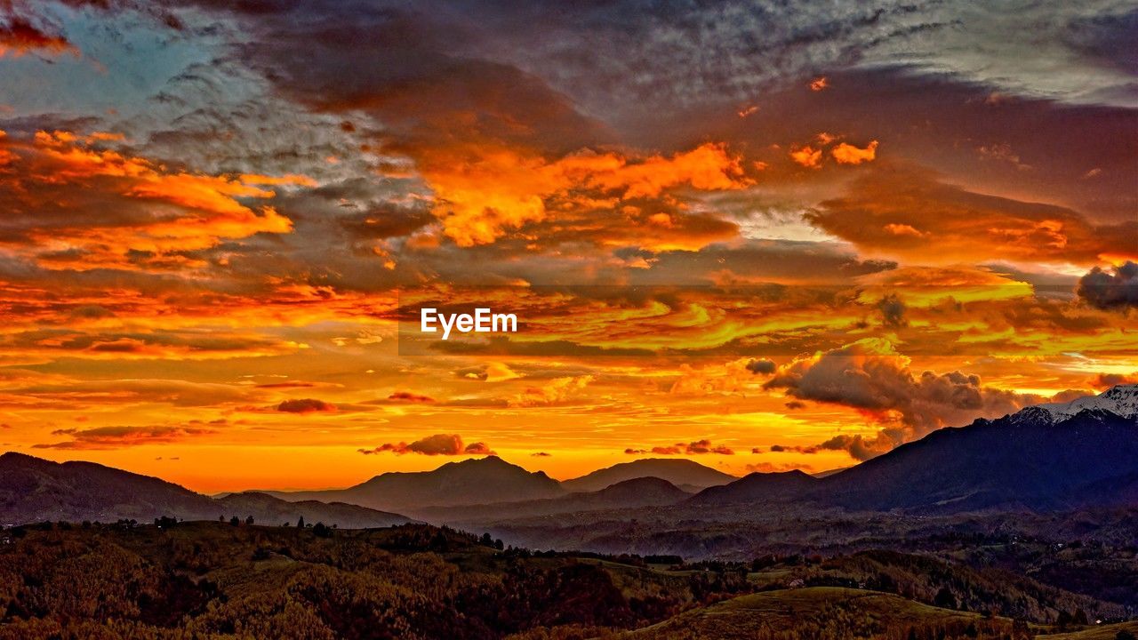sky, environment, mountain, landscape, scenics - nature, beauty in nature, cloud, sunset, nature, dramatic sky, mountain range, tranquility, dawn, evening, orange color, land, no people, afterglow, travel destinations, horizon, red sky at morning, sunlight, sun, tranquil scene, travel, non-urban scene, outdoors, multi colored, idyllic, tourism, awe, yellow, cloudscape, moody sky, red, dramatic landscape, twilight, rock, remote, atmospheric mood