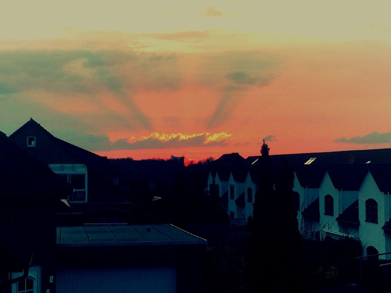 Residential district against orange sky during sunset