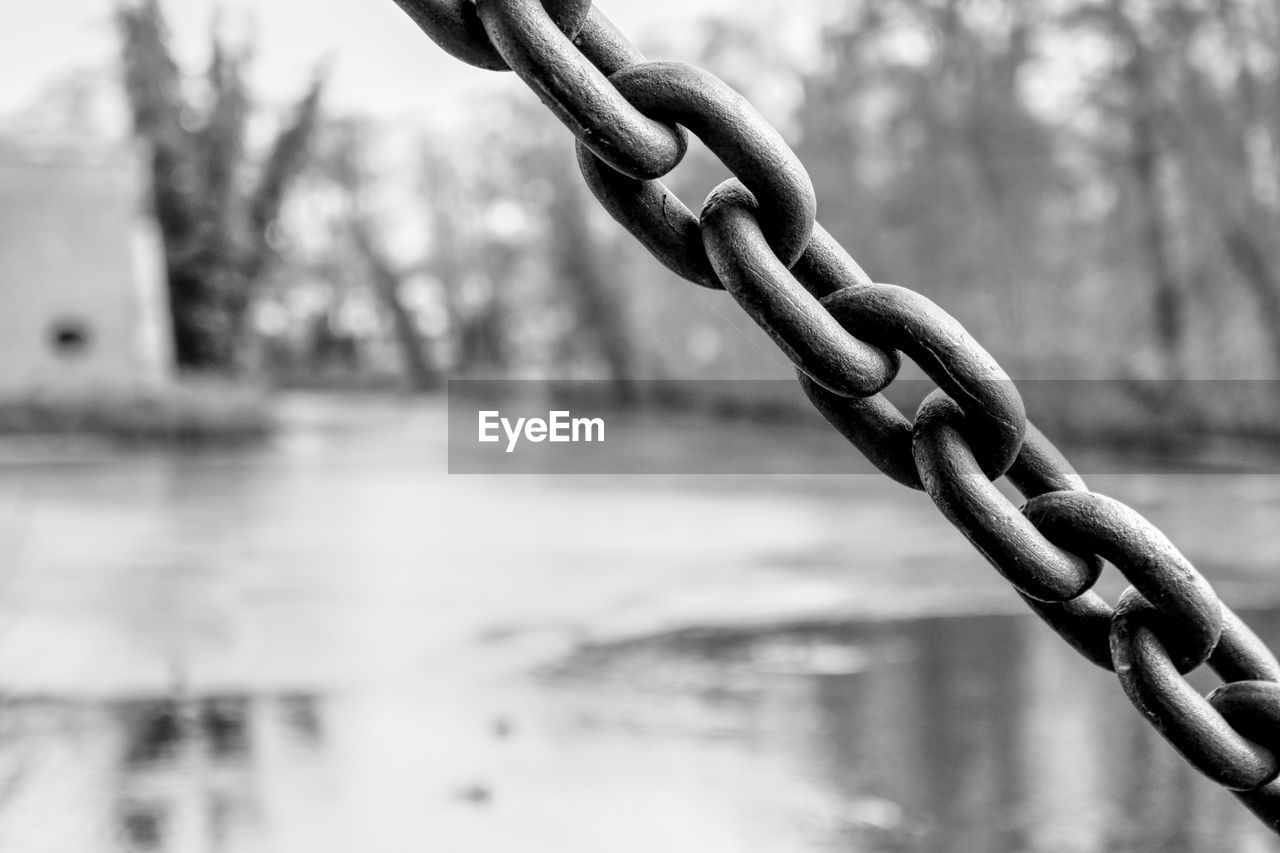 CLOSE-UP OF ROPE TIED UP OF METAL CHAIN