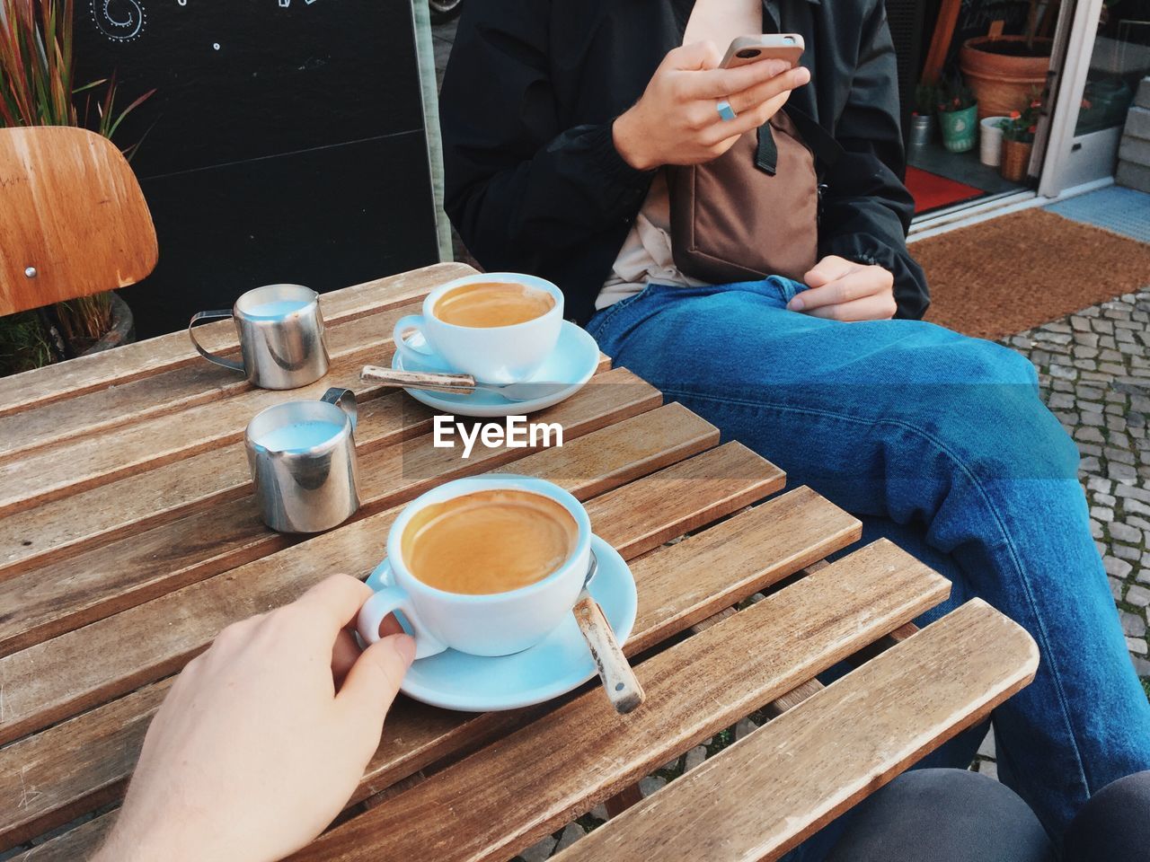 Cropped view of friends drinking coffee at a cafe