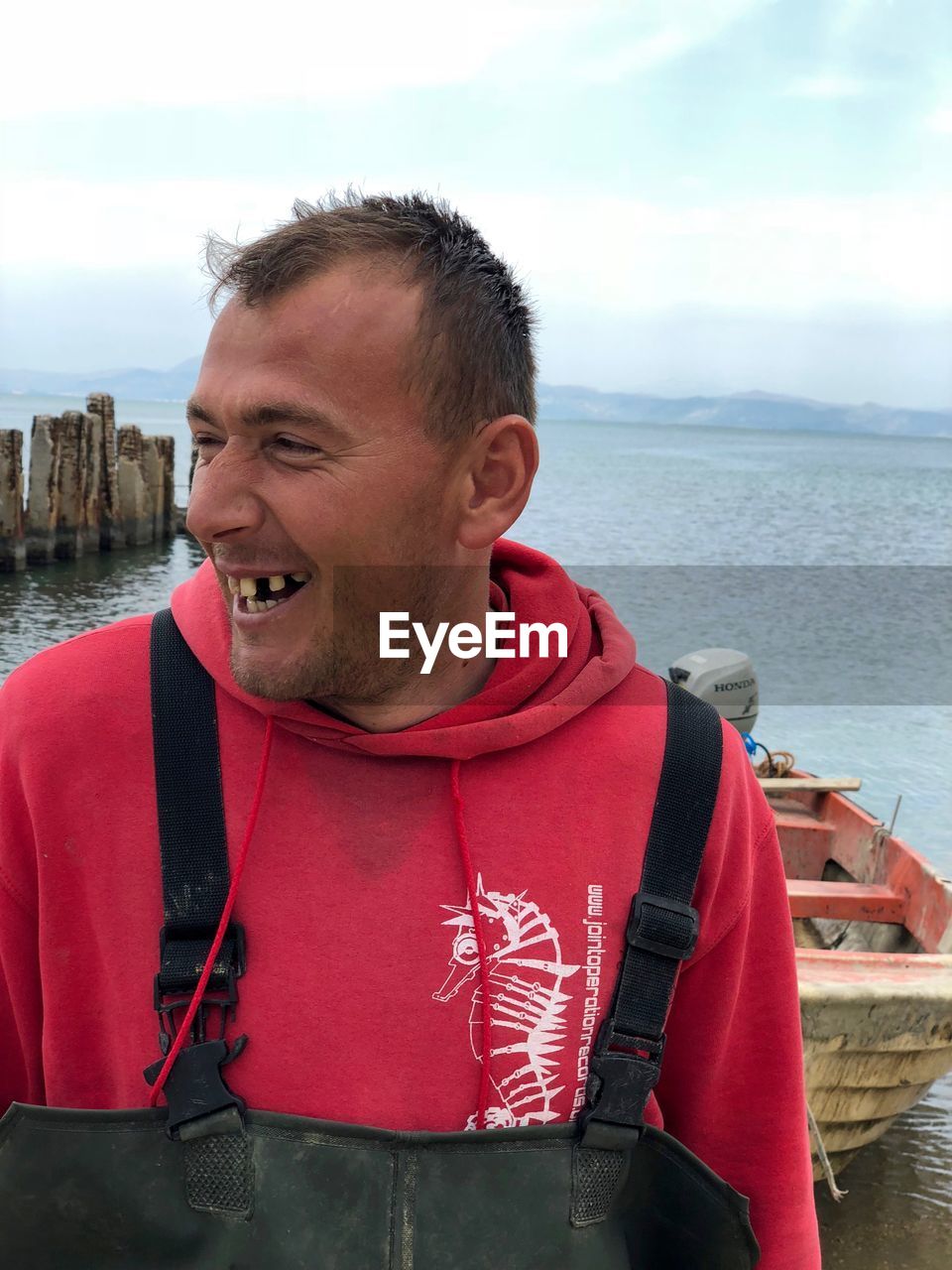 Smiling man standing against sea