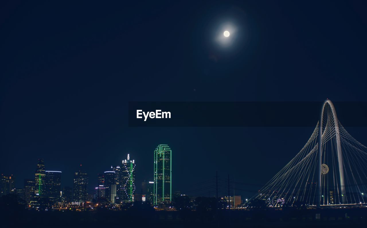 Illuminated city against sky at night