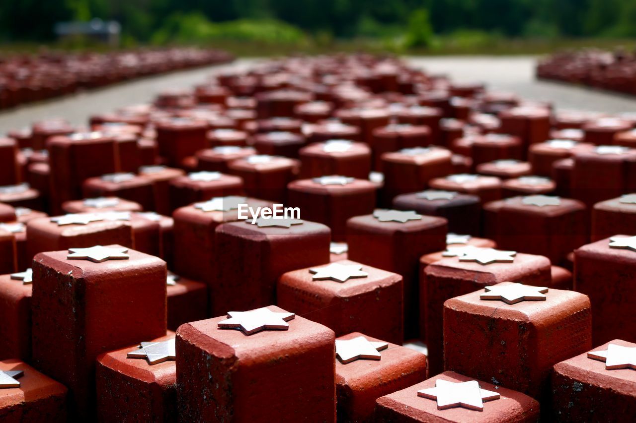 red, chocolate, in a row, no people, large group of objects, focus on foreground, food, brick, food and drink