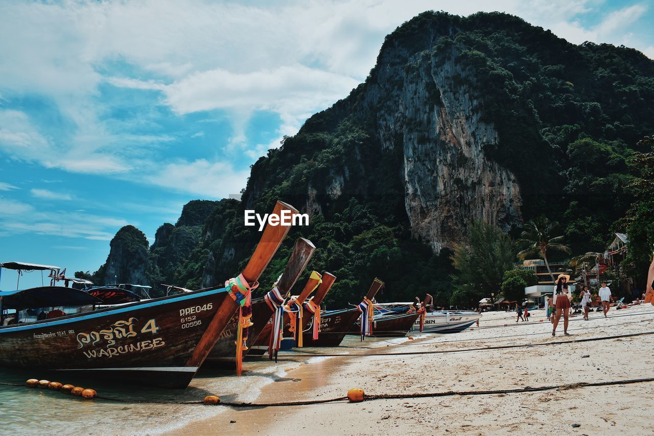 GROUP OF PEOPLE ON BEACH AGAINST SKY