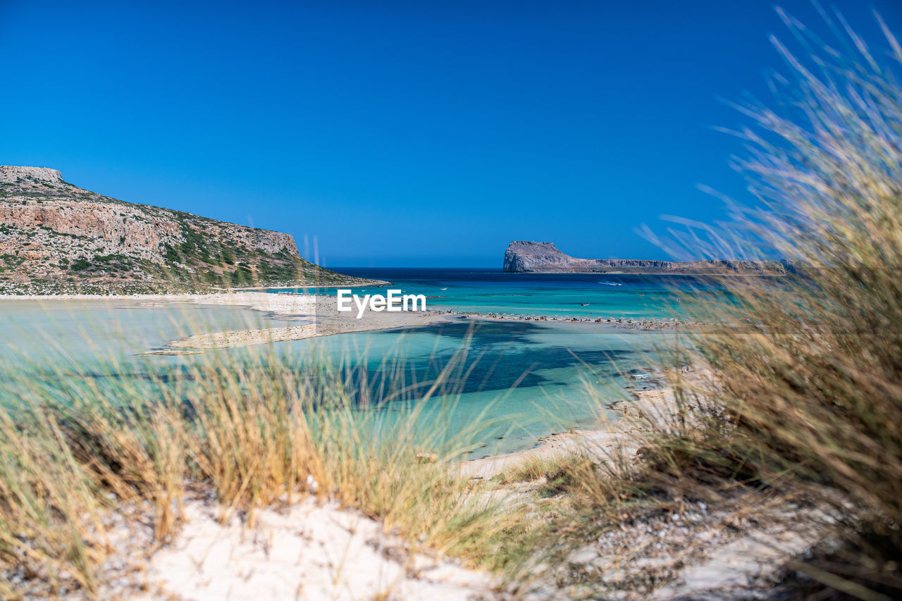 Scenic view of sea against clear blue sky