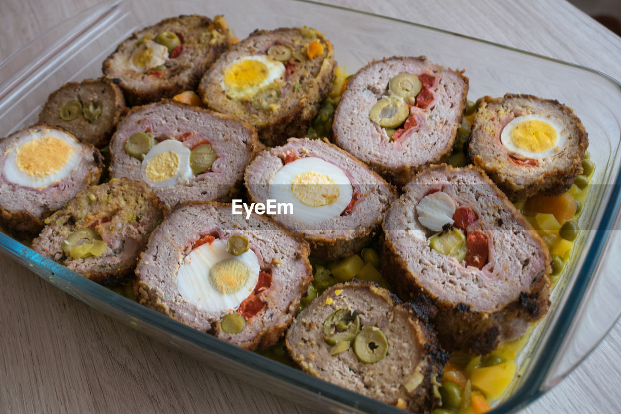 Meat roll stuffed with egg, olives, ham and pepper