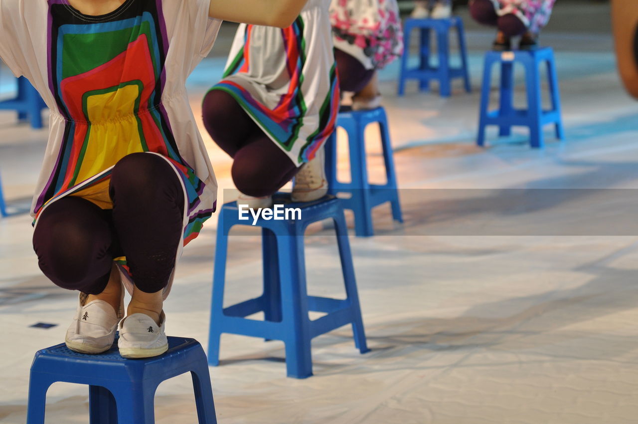 Low section of women performing on stools