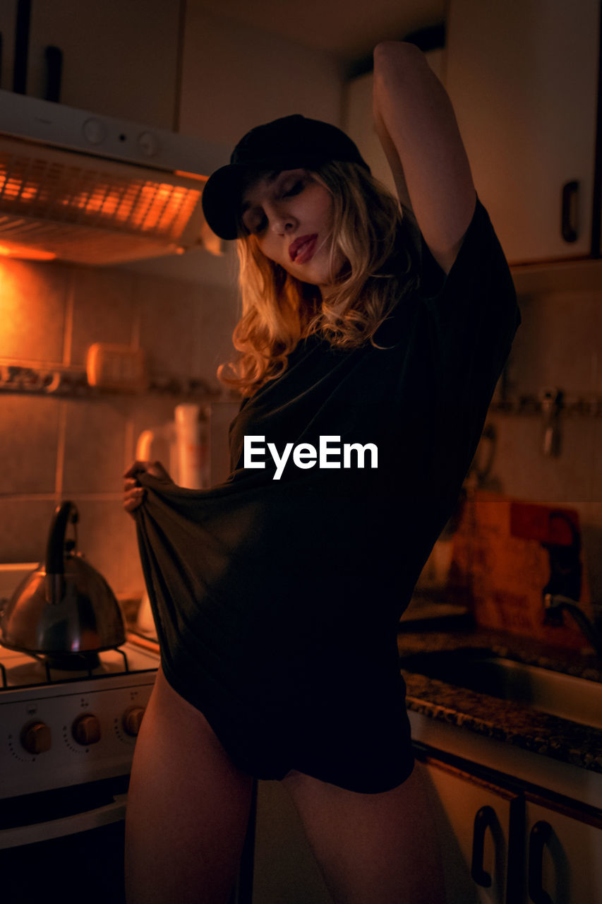 Young sensual woman standing in kitchen