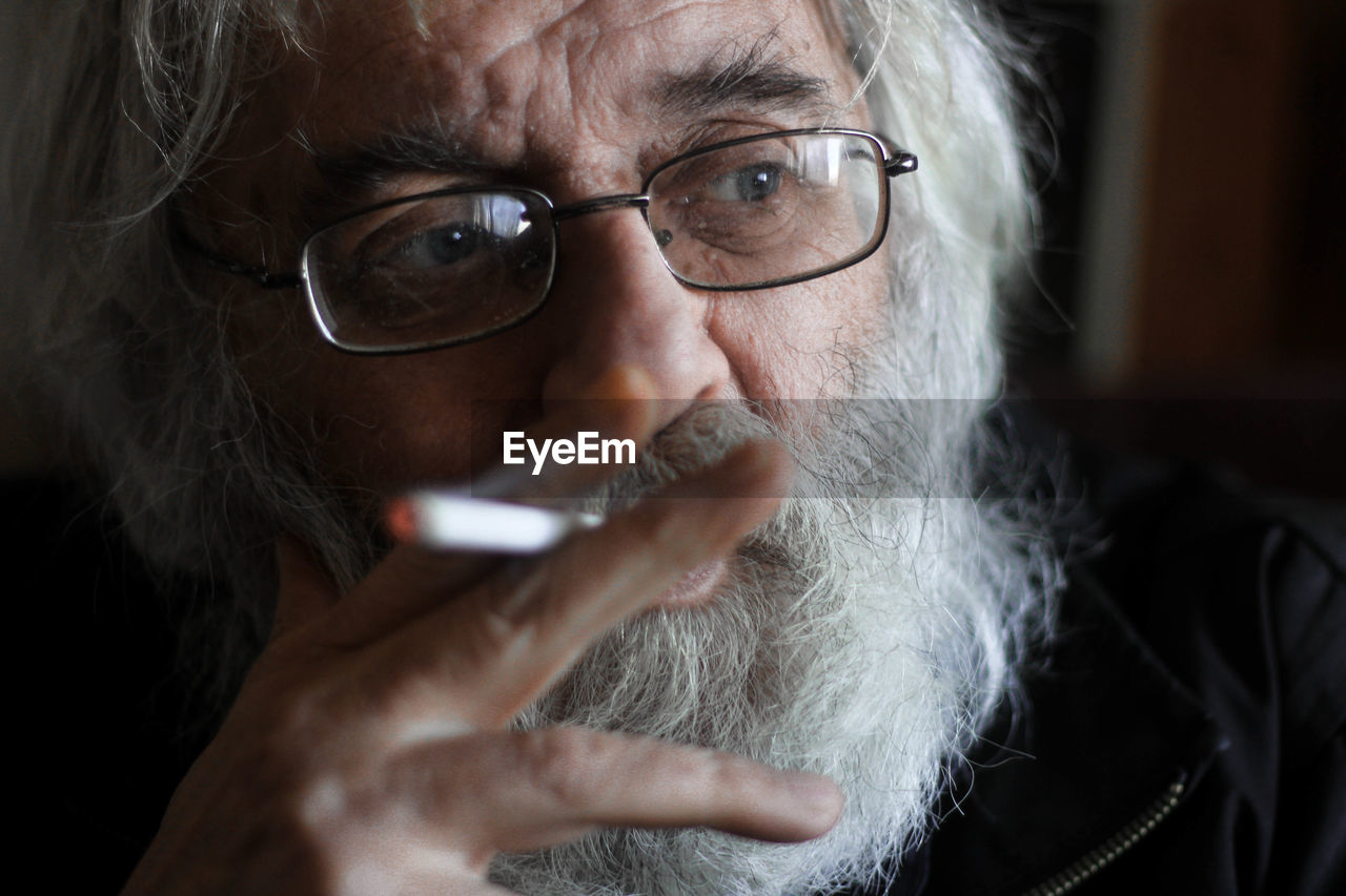 Close-up of thoughtful senior man smoking cigarette