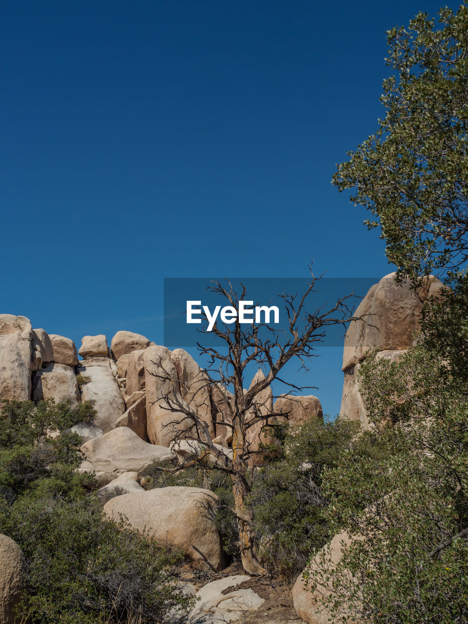 Scenic view of cliff against clear blue sky