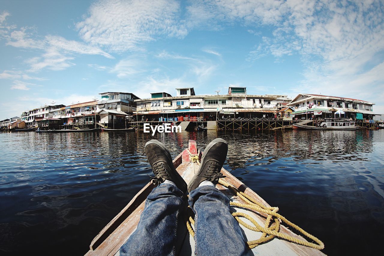 MAN ON BOAT AGAINST BRIDGE