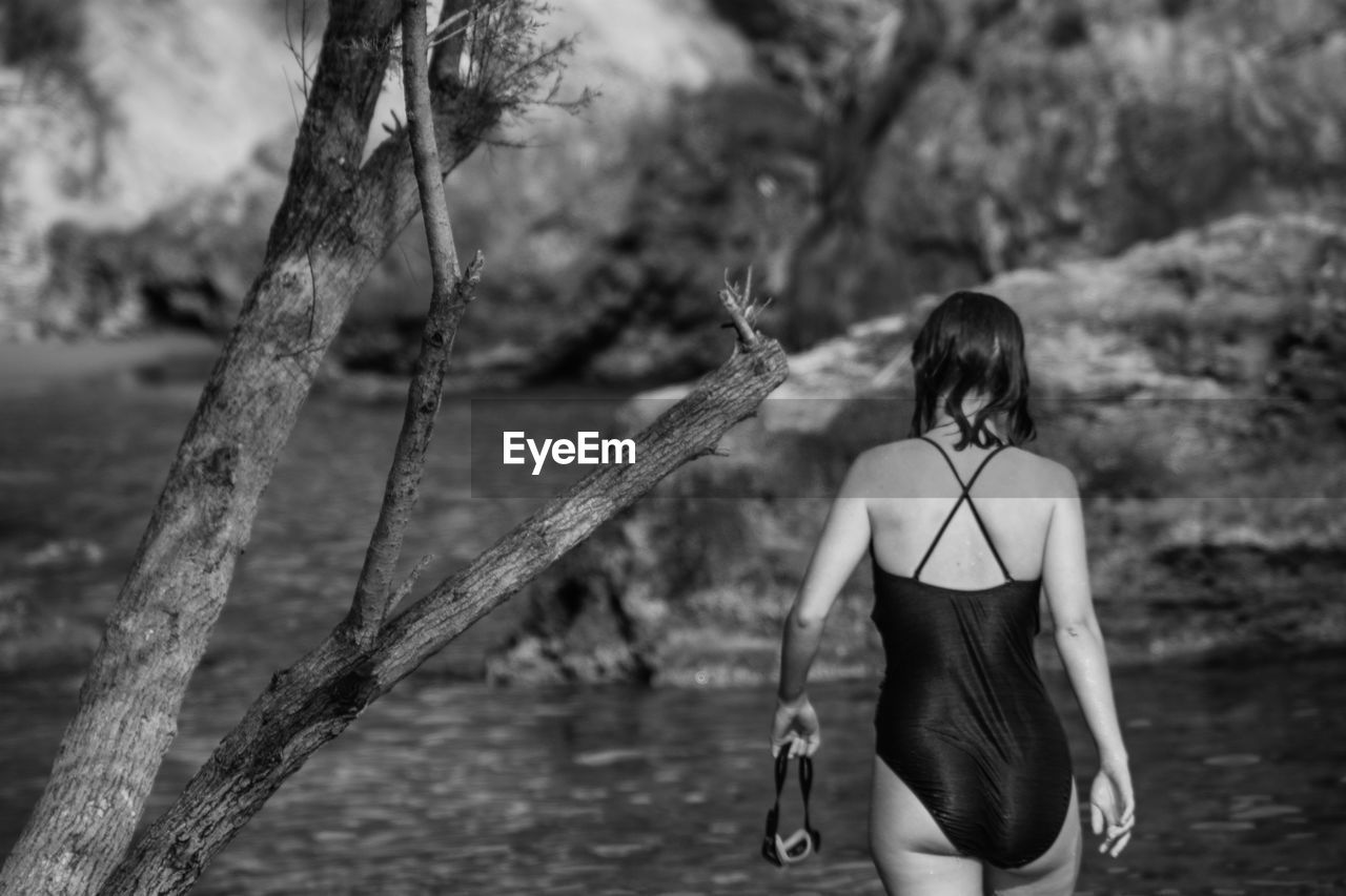 Rear view of woman wearing swimwear while standing in sea