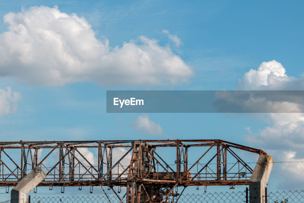 cloud, sky, architecture, built structure, bridge, nature, blue, transportation, metal, water, no people, outdoors, day, industry, travel, travel destinations, environment, low angle view, roller coaster