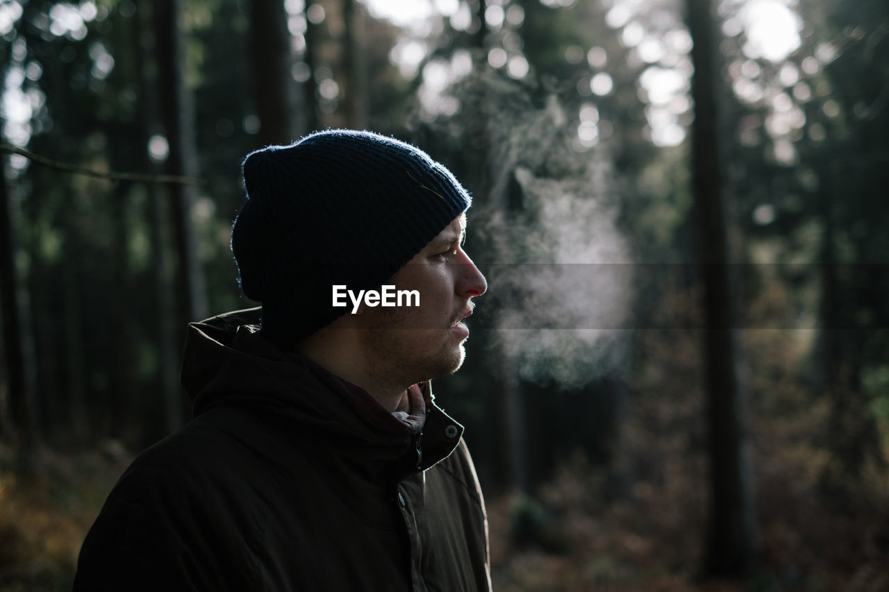 Close-up of young man standing in forest