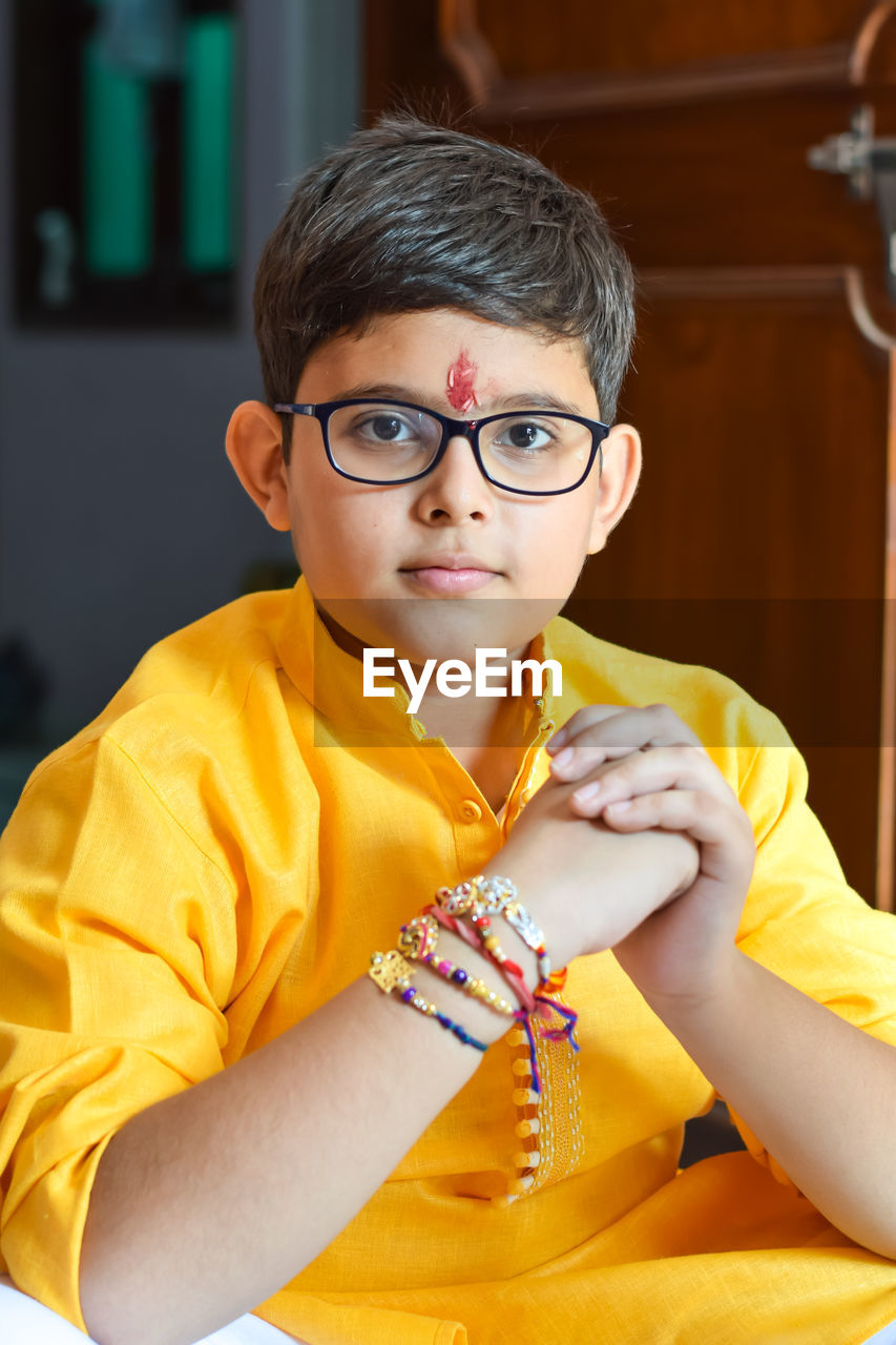 Portrait of boy wearing eyeglasses while sitting at home