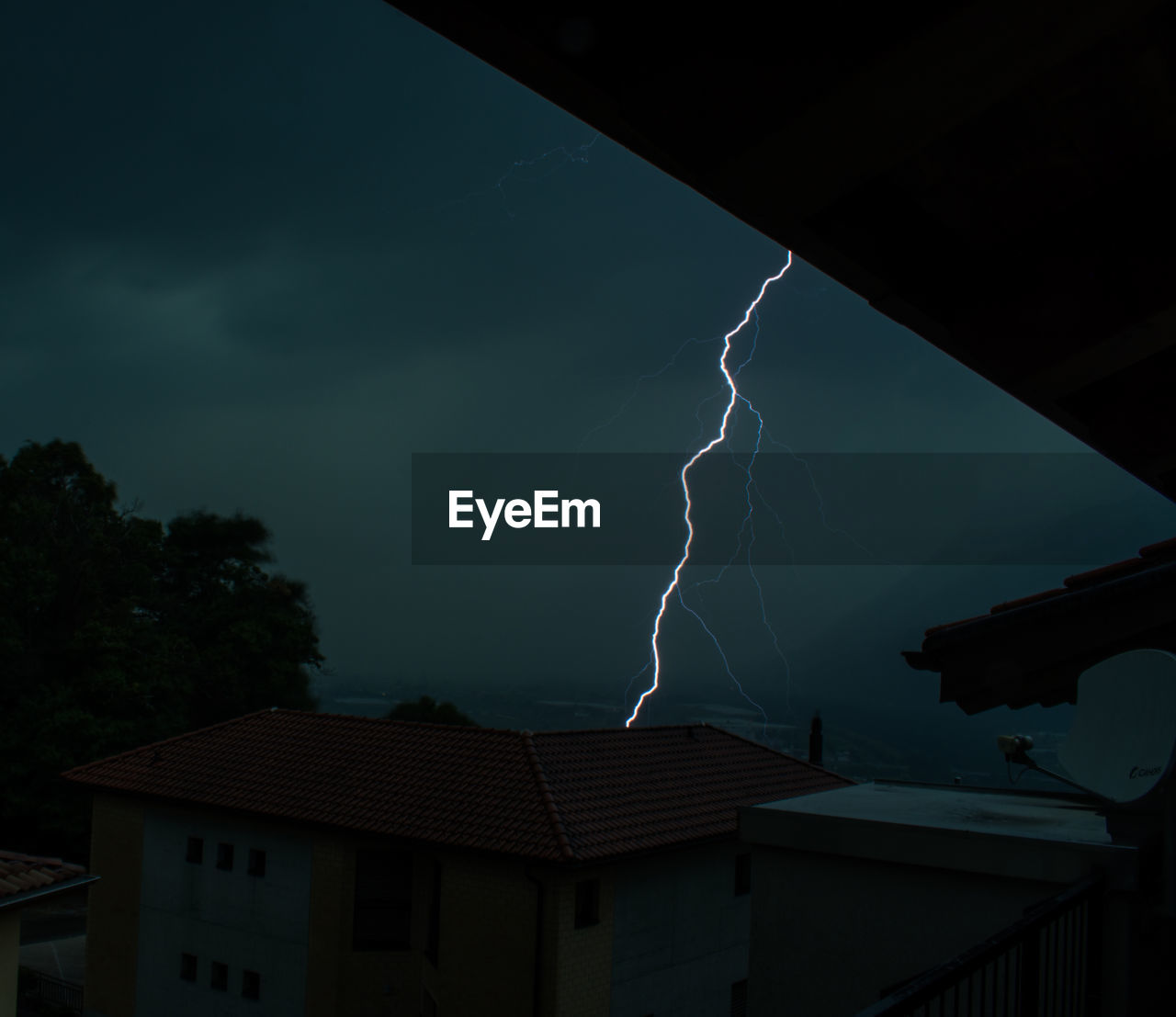 LIGHTNING OVER BUILDINGS AGAINST SKY