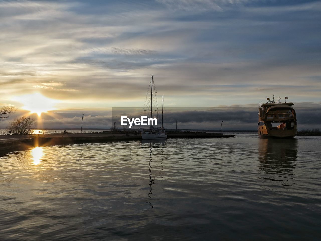 Scenic view of sea against cloudy sky during sunset