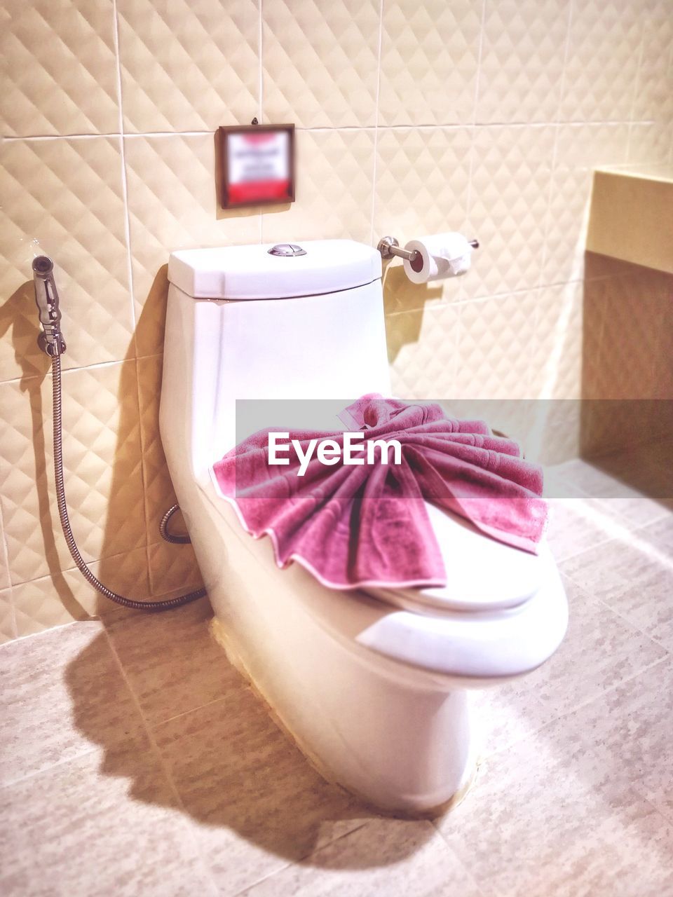 CLOSE-UP OF PINK ROSE ON TABLE IN BATHROOM