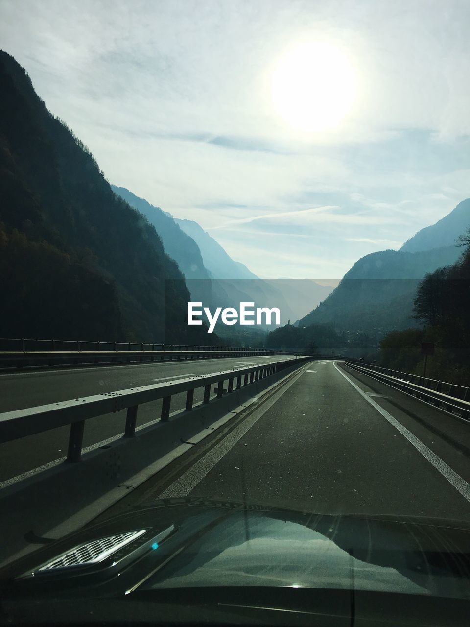 Road by mountains against sky