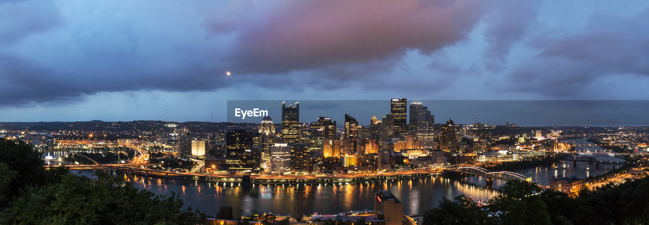 Illuminated cityscape against sky at night