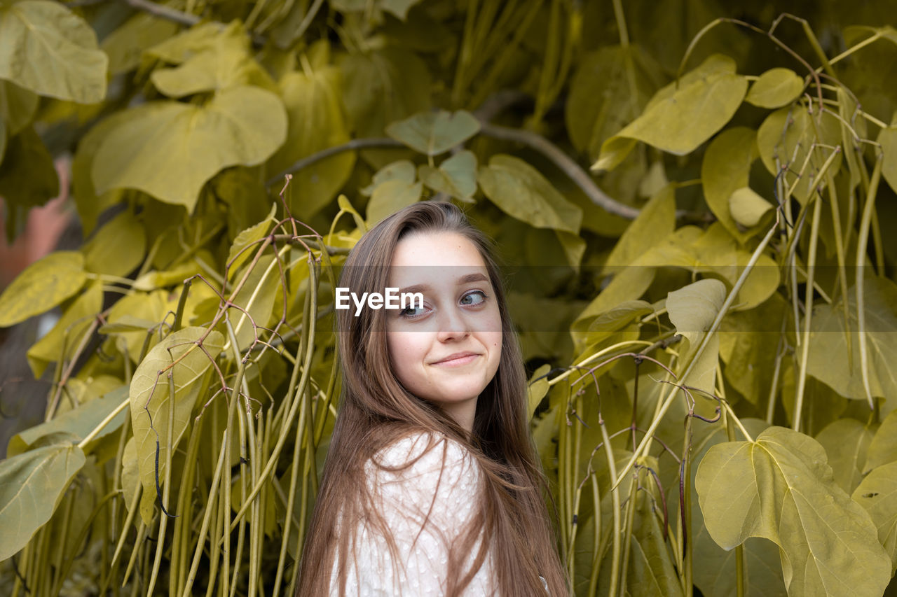 Portrait of a smiling young woman with leaves