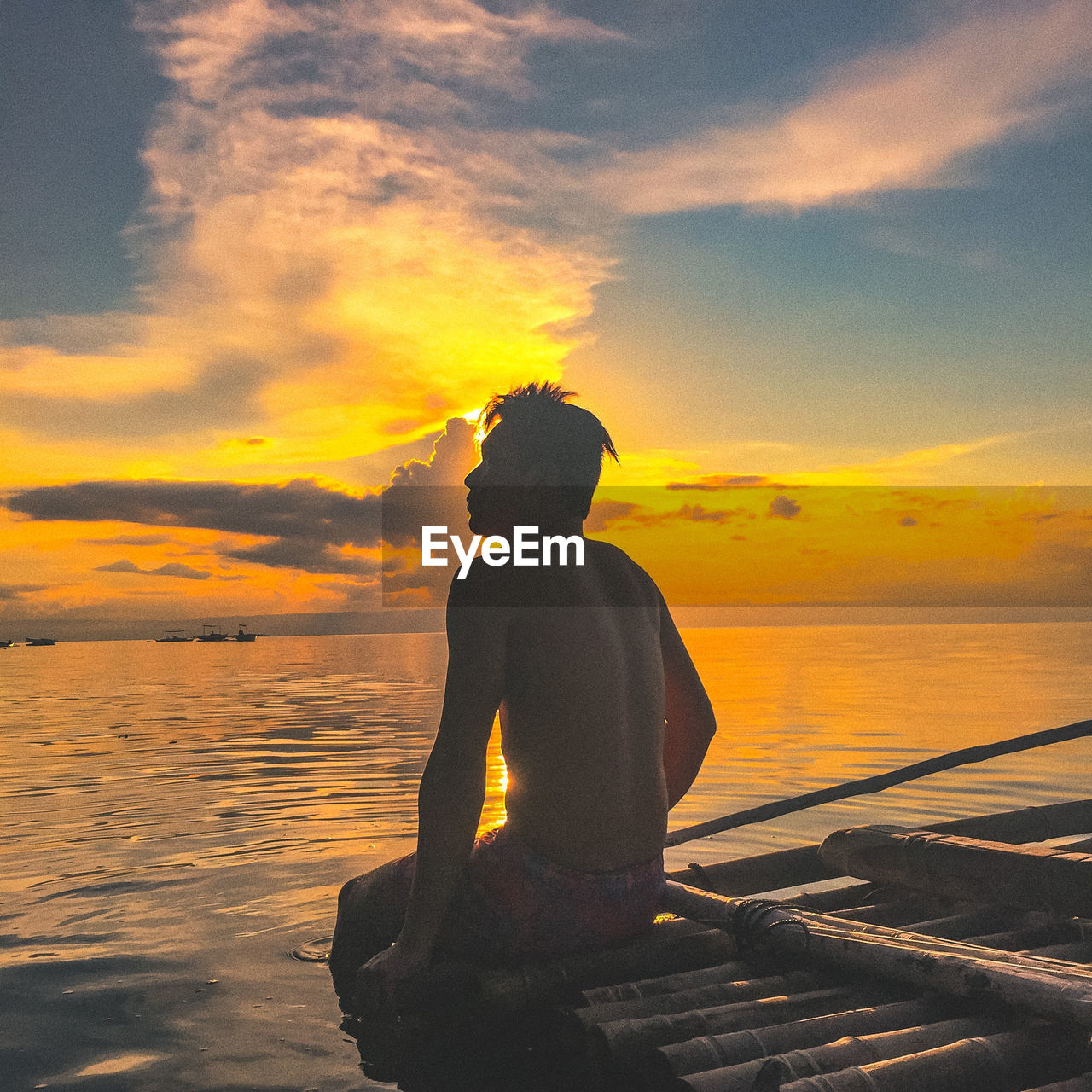 Silhouette man looking at sea against sky during sunset