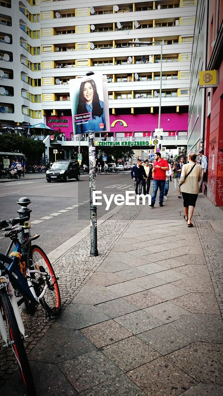 PEOPLE STANDING ON BICYCLE IN CITY