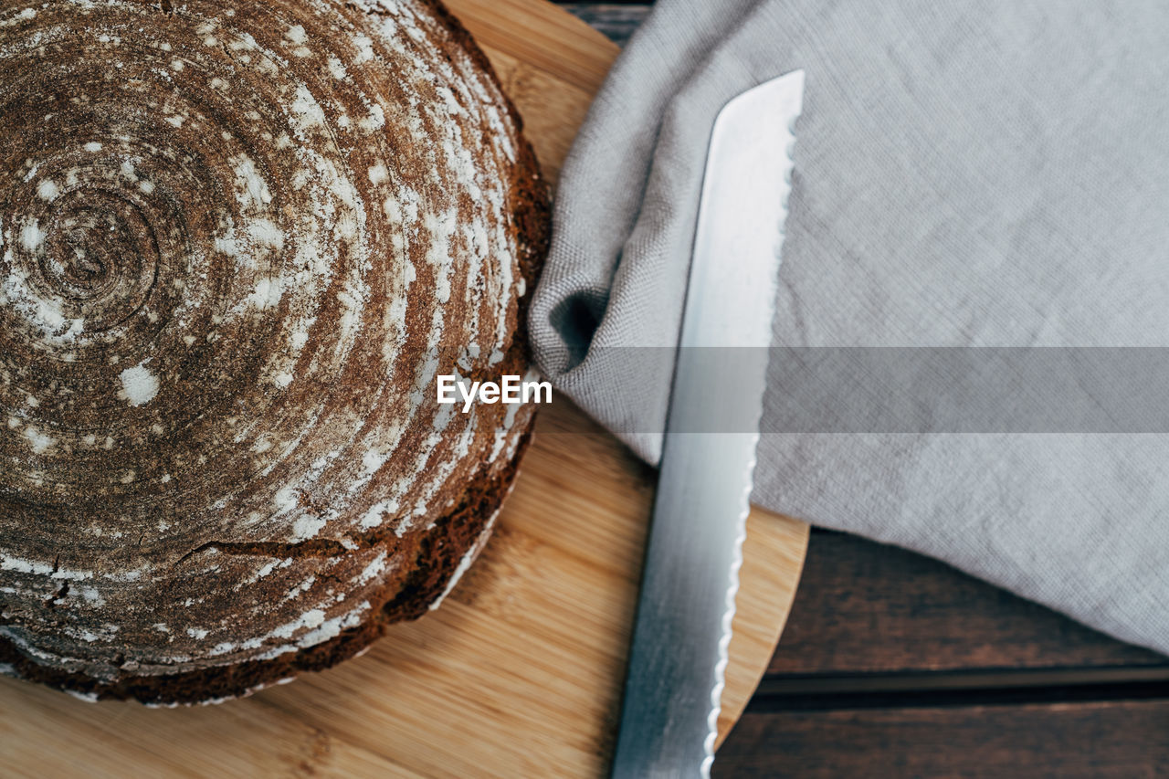 Homemade bread and knife on wooden plate