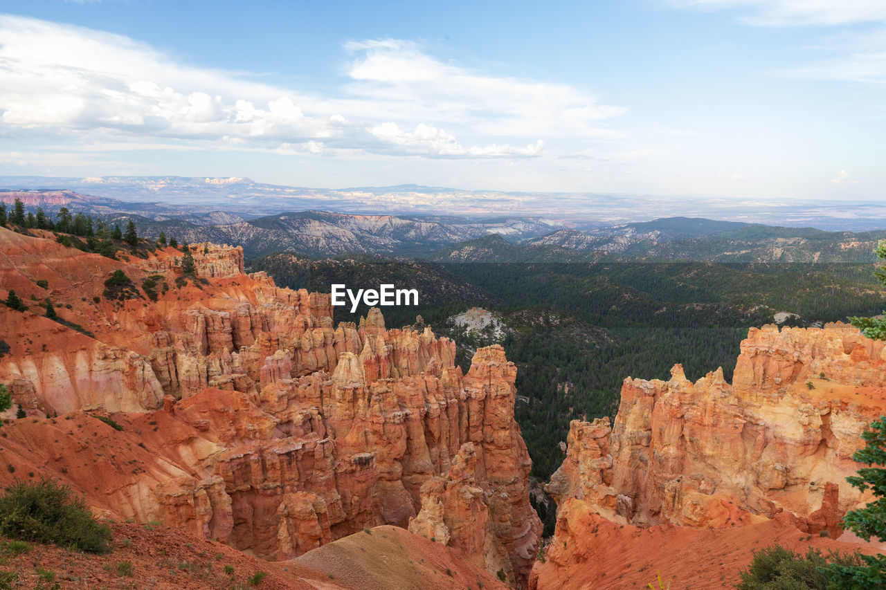 Rock formations on landscape against cloudy sky