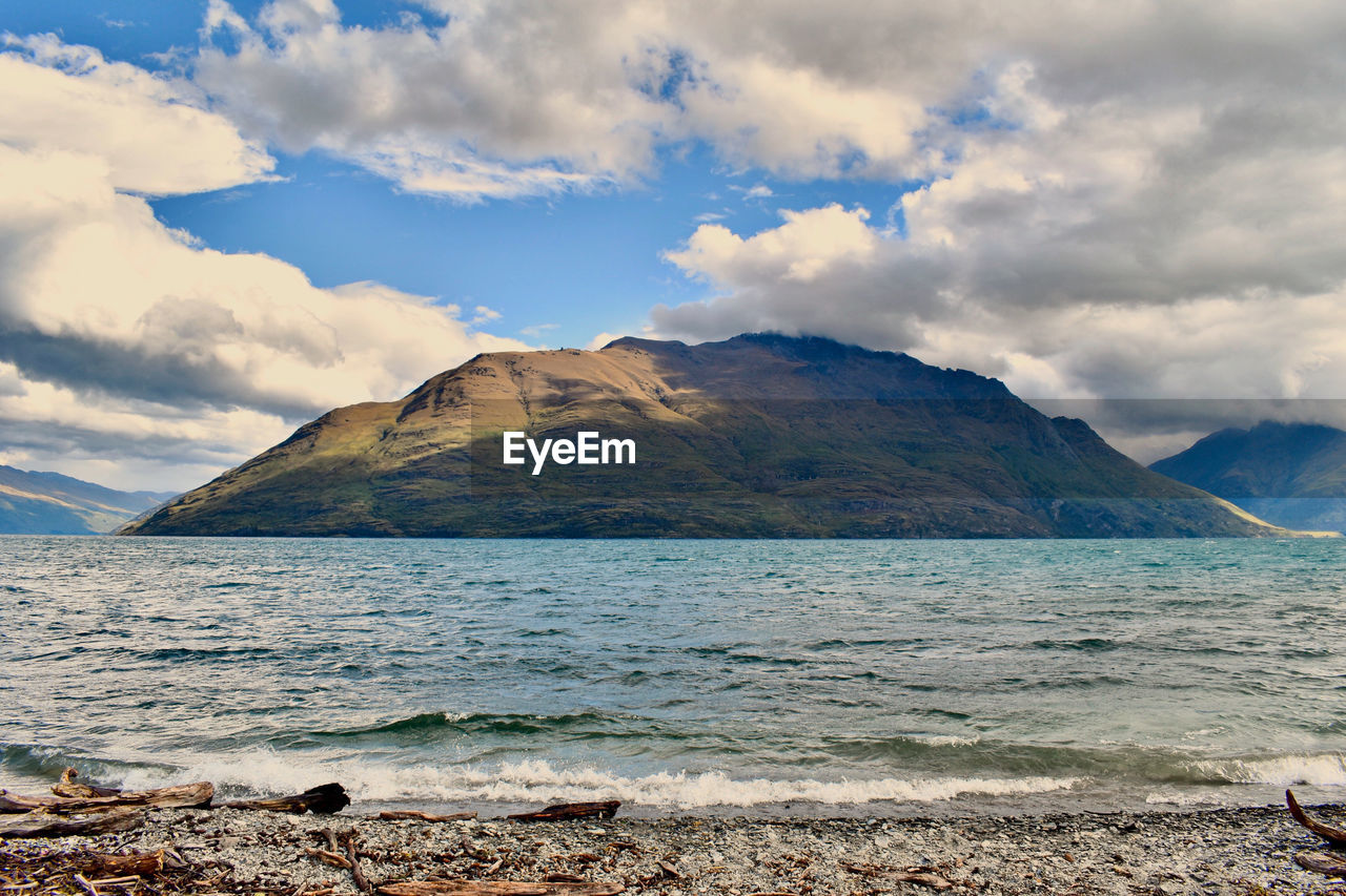 Scenic view of sea and mountains against sky