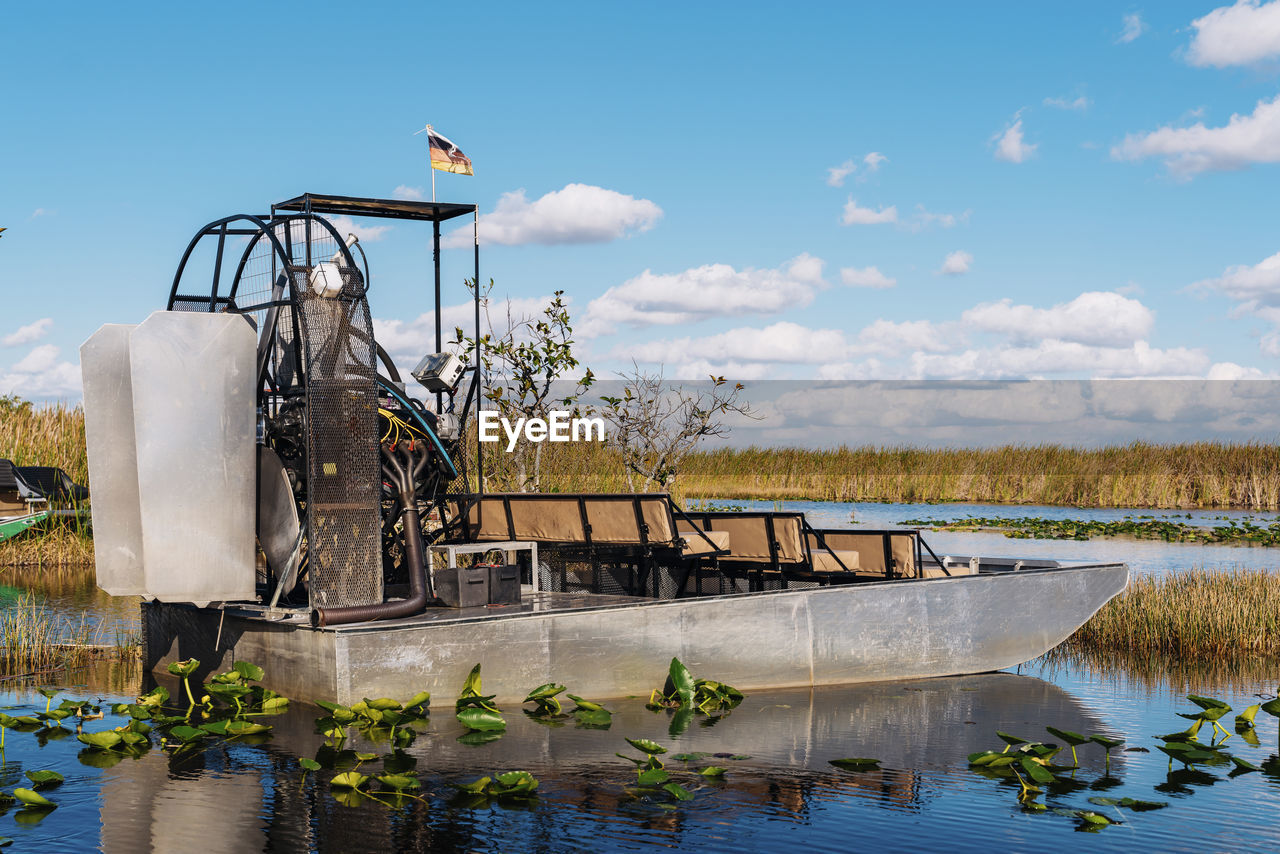 Airboat in lake at everglades national park against blue sky