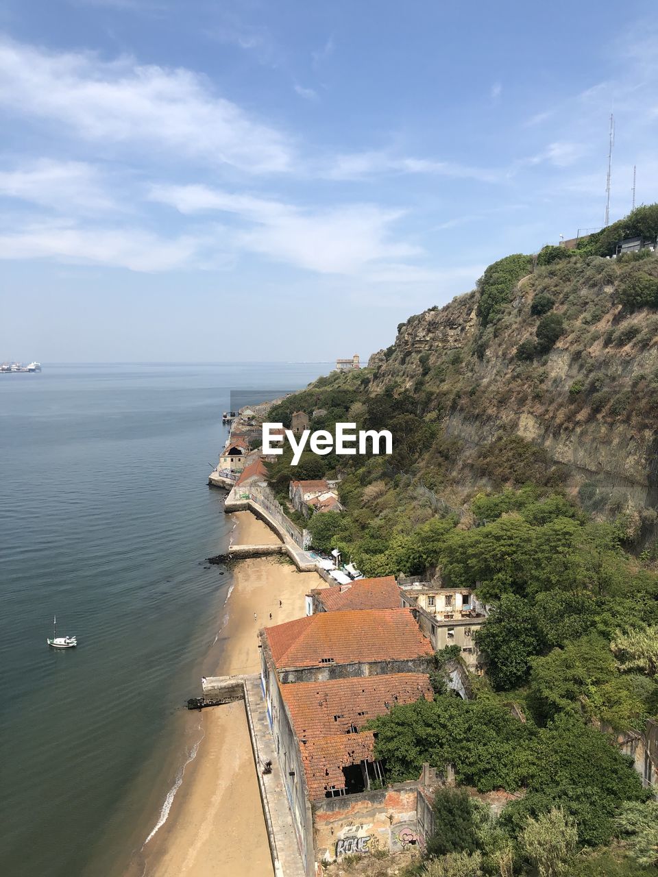 HIGH ANGLE VIEW OF SEA BY BUILDINGS AGAINST SKY