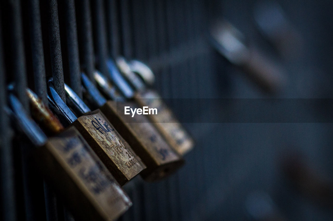 Close-up of rusty padlocks hanging on railing