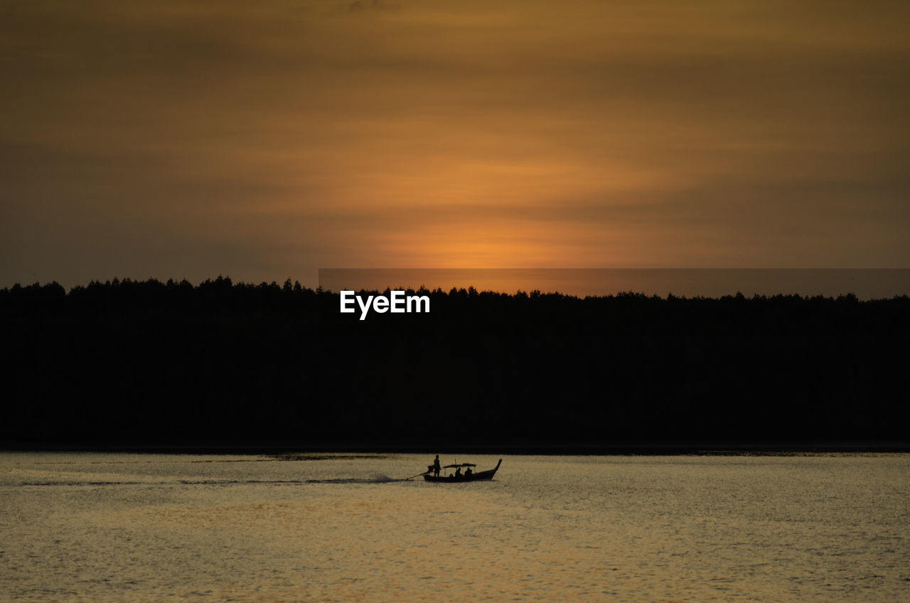 Silhouette boat sailing in sea against sky during sunset