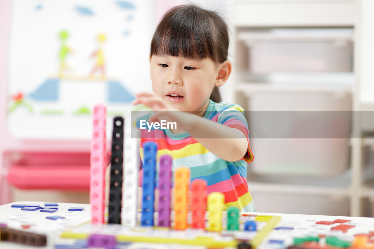 Portrait of cute boy with toy on table