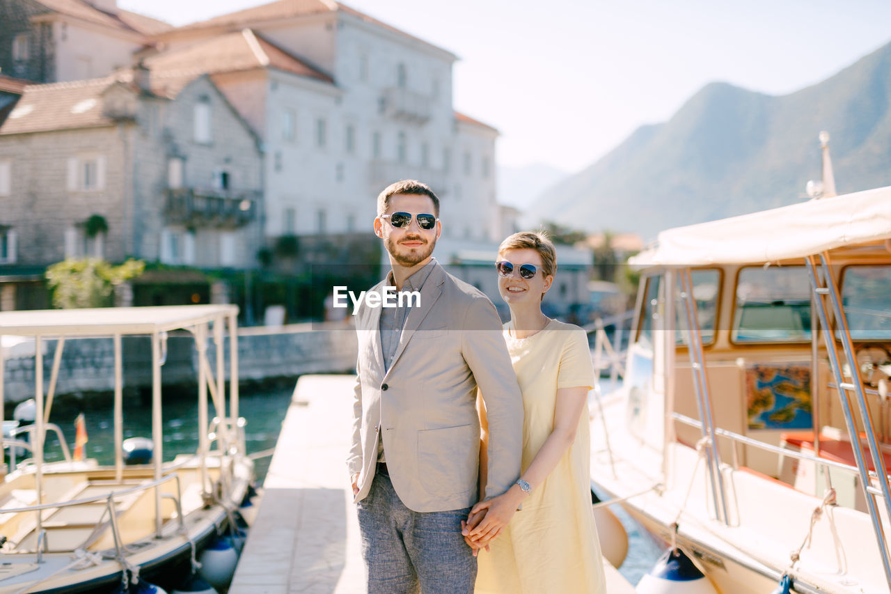 PORTRAIT OF YOUNG MAN IN SUNGLASSES AT BOAT