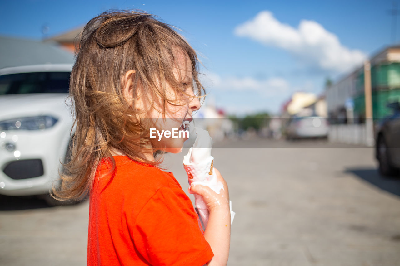 side view of young woman holding ice cream cone