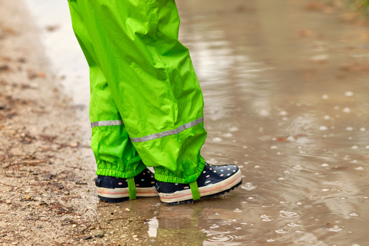 Low section of woman standing on wet road