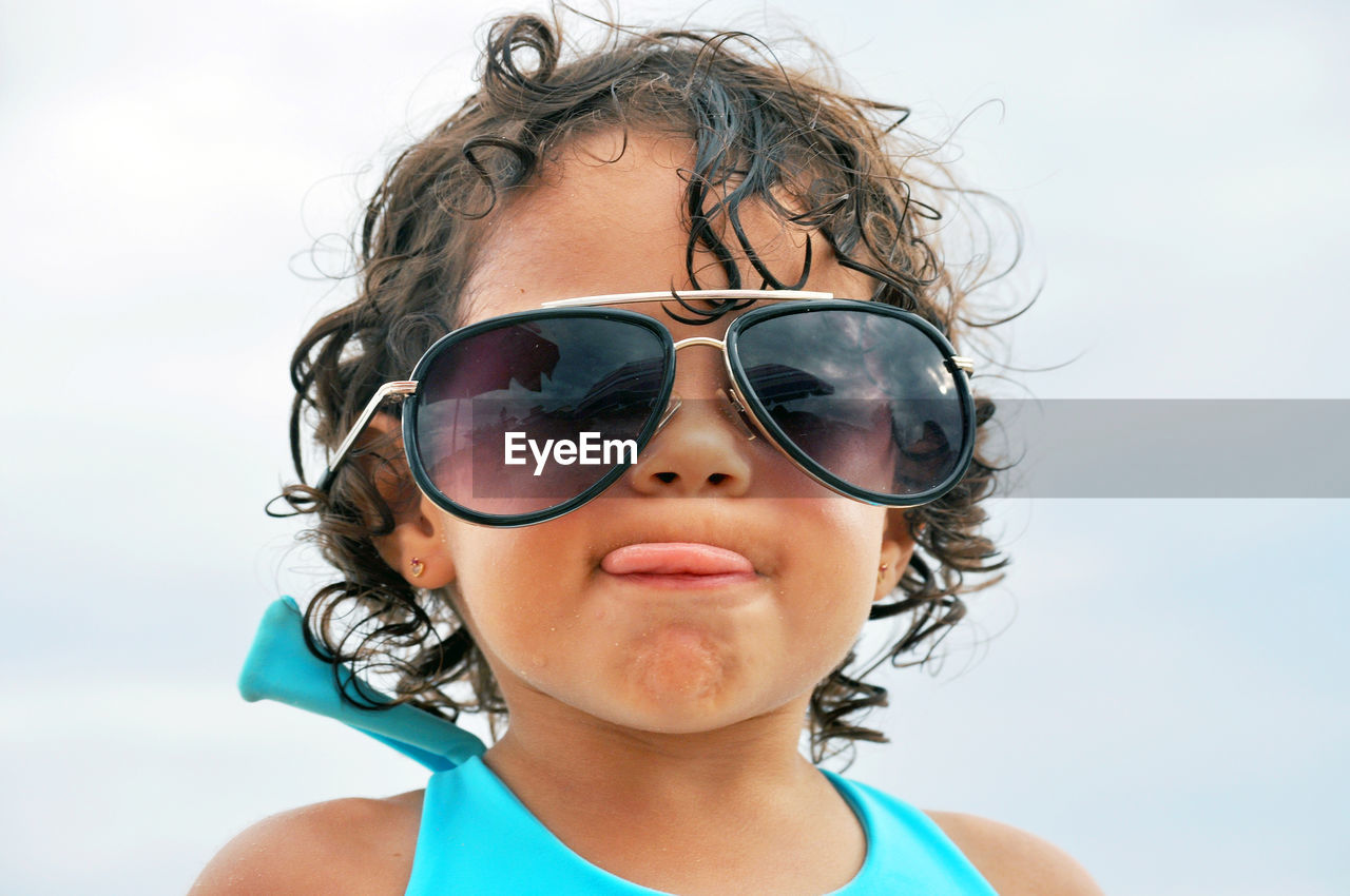 Portrait of girl wearing sunglasses against sky