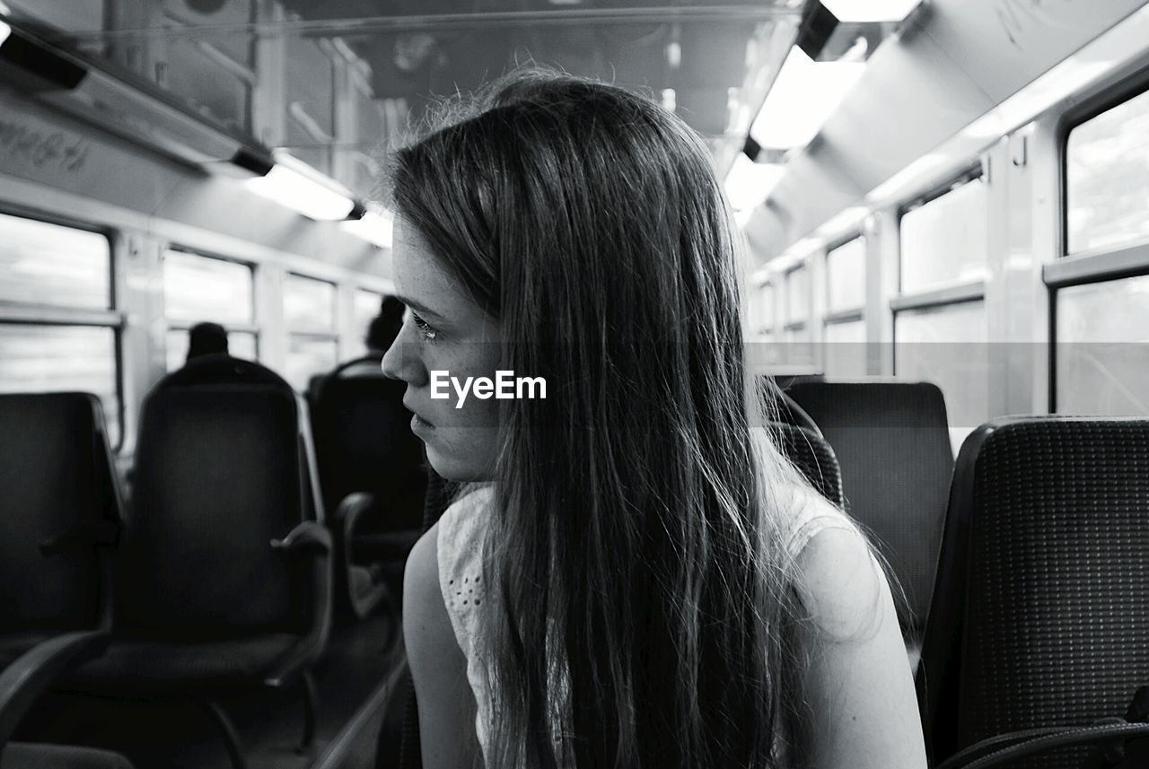 Young woman with long hair sitting in train