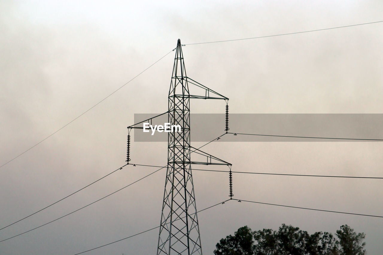 LOW ANGLE VIEW OF ELECTRICITY PYLON BY TREES AGAINST SKY