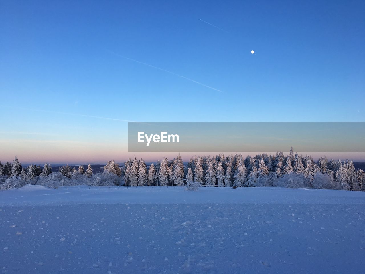 Scenic view of snow covered landscape against blue sky