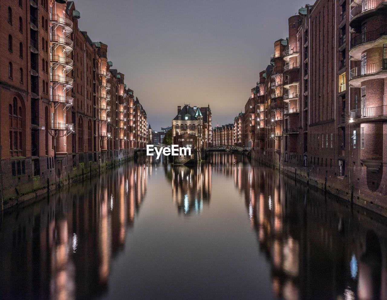 Reflection of illuminated buildings on water at dusk