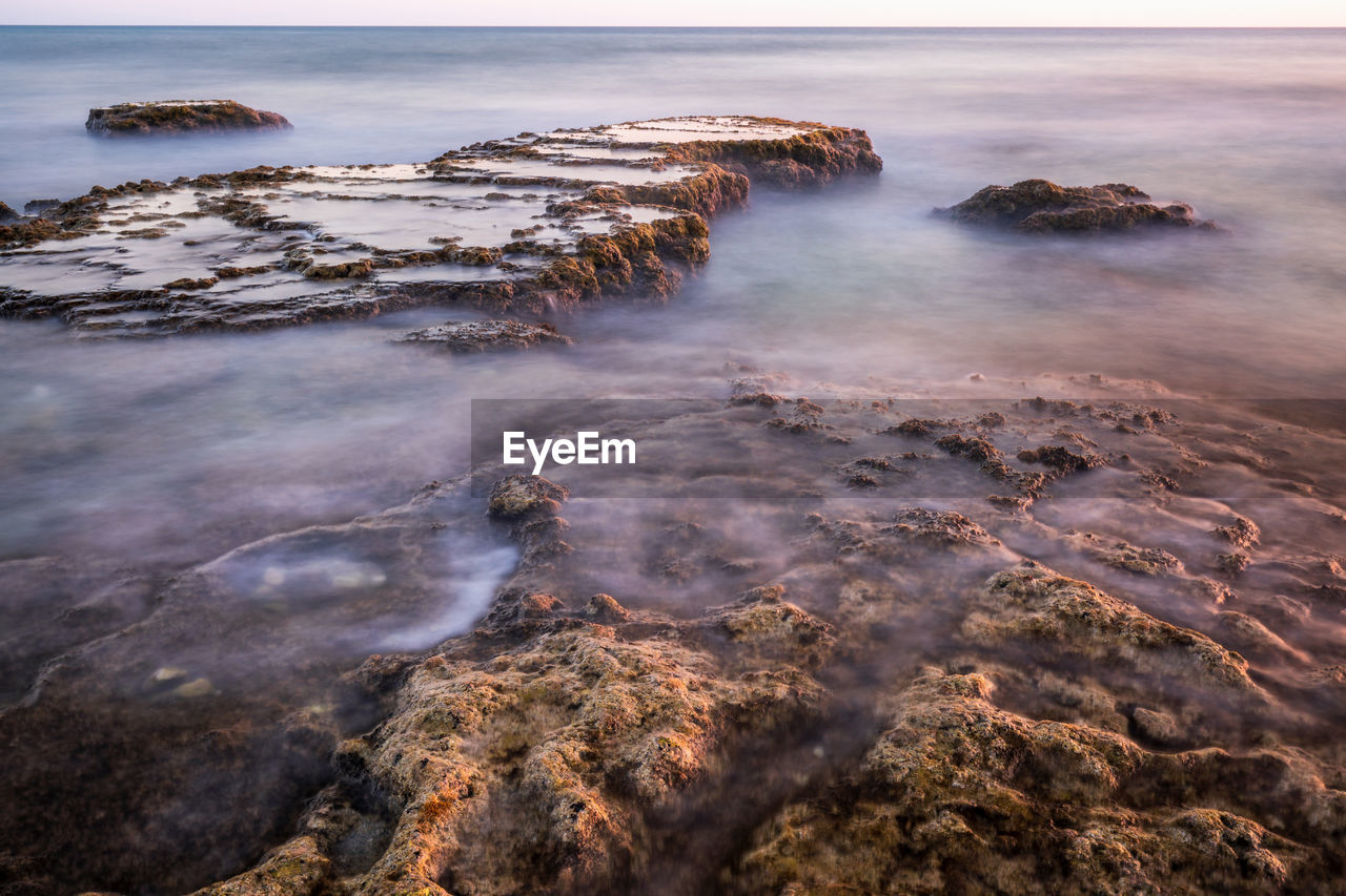 Aerial view of rocks on beach against sky