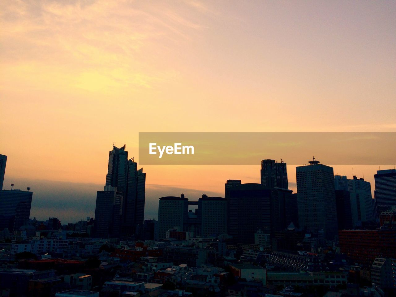 Silhouette buildings against sky during sunset in city