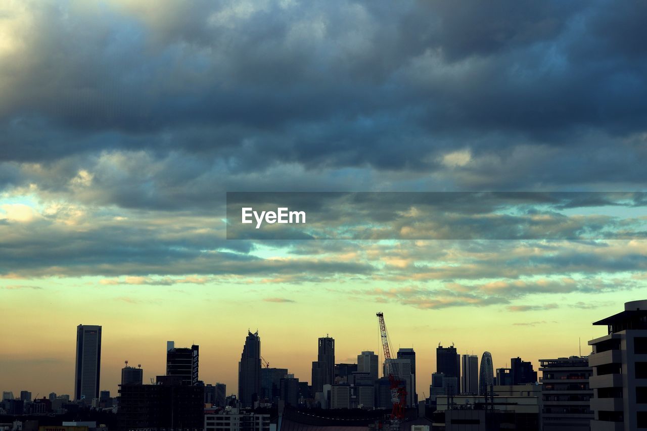 Buildings in city against sky during sunset