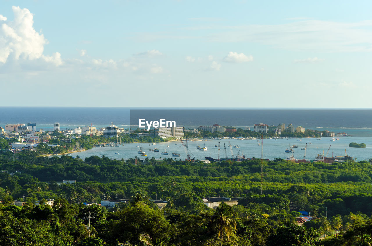 Scenic view of sea by city against sky