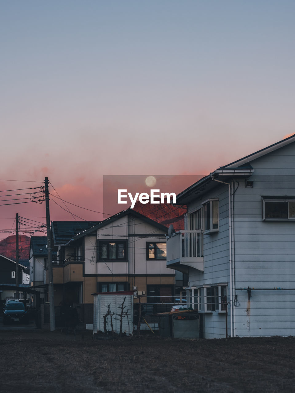 Houses and buildings against sky at sunset